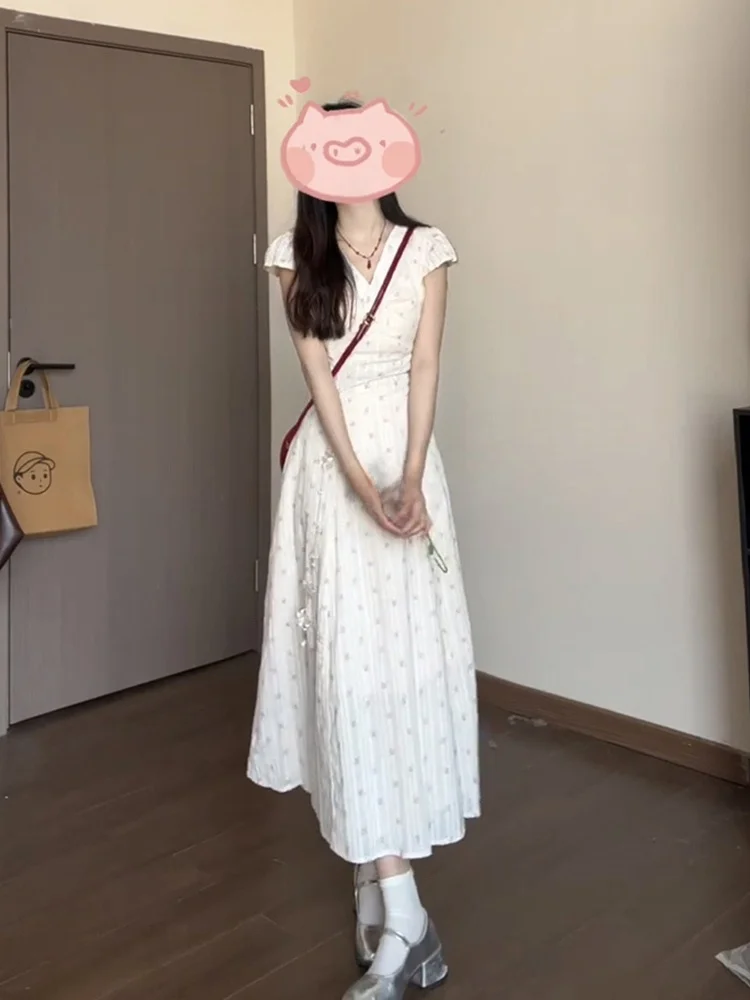 เดรสยาวทรงเอลายดอกไม้สีขาว คอวี สำหรับผู้หญิง ฤดูร้อน 2025 รุ่นใหม่ สไตล์ชายหาด เอวสูง ผ้าฝ้าย หวาน สไตล์เดรสชายหาด