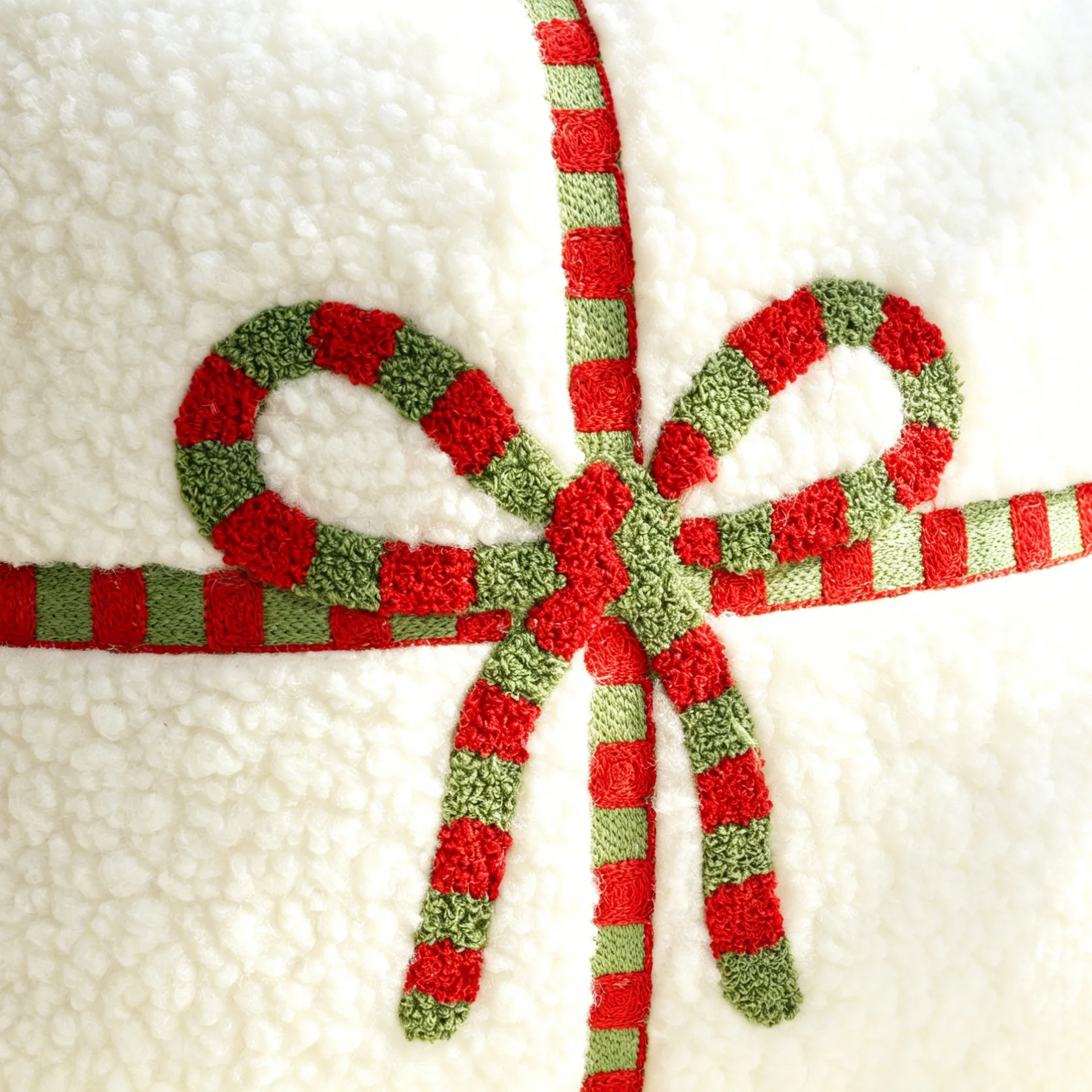 Red-and-green embroidered bow on white pillow cover