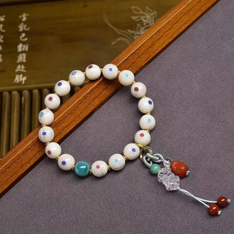 

Браслет из бусин с инкрустацией из кости в сочетании с бусинами Дзи, трехсторонним соединителем, символизирующим физическое и духовное равновесие, винтажный стиль.