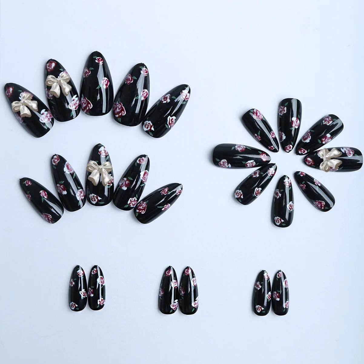 24枚入り 光沢のある黒アーモンド型つけ爪 ピンクの花柄プリント付き プレスオンネイル オーロラリボン飾り付き スイートでクールなフェイクネイルパッチ