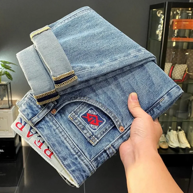

2026 New Spring Style Men's Denim Jeans Slim Fit Slight Stretch Embroidered Decoration Trendy Pocket Design Red Label Versatile
