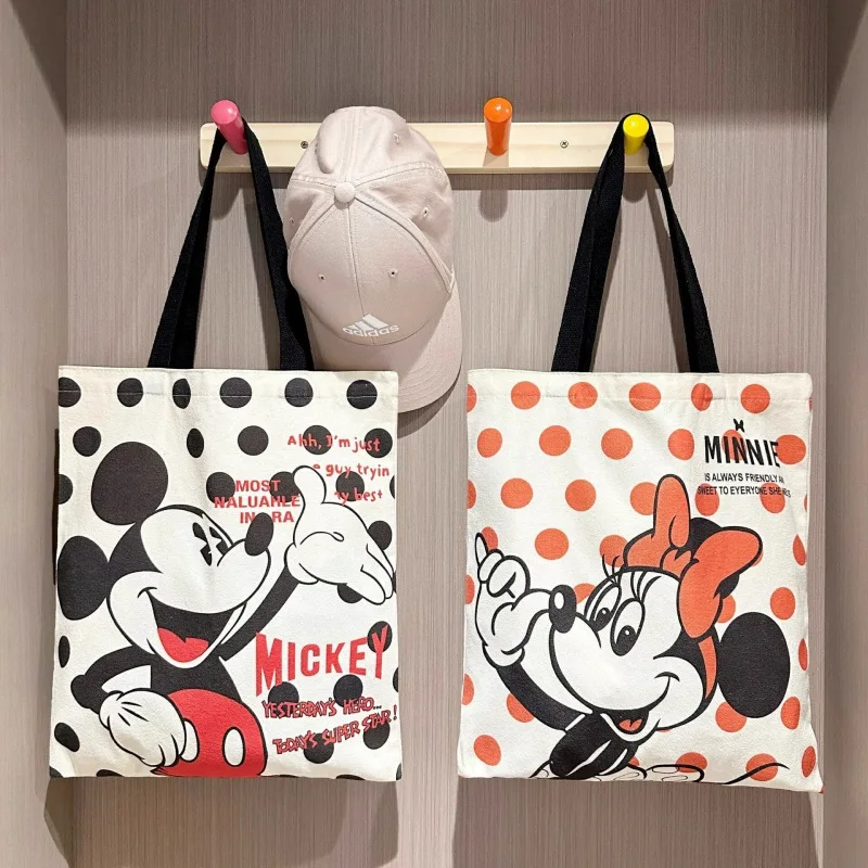 ใหม่ Kawaii Mickey Mouse ผ้าใบกระเป๋าอะนิเมะ Minnie Mouse อุปกรณ์เสริมกระเป๋าสะพายนักเรียนกระเป๋าเป้สะพายหลังการ์ตูนมือถือช้อปปิ้งกระเป๋า