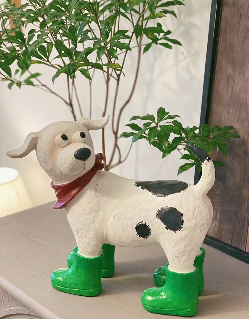 A Cartoon Resin Decorative Item for A Courtyard Garden with White and Black Dots Wearing Green Shoes and A Red Scarf