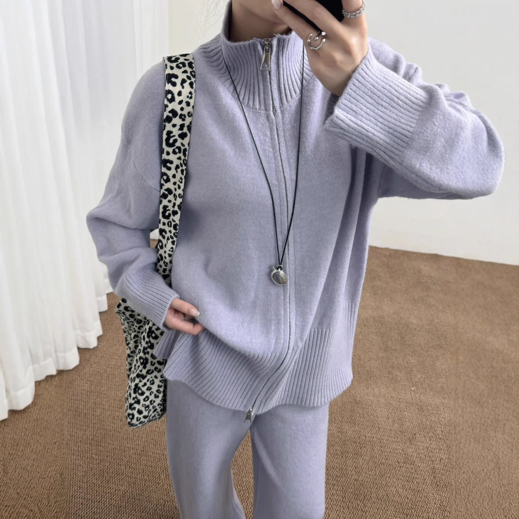 Setelan Dua Potong Kasual untuk Wanita dengan Cardigan Rajut Gaya Longgar Berwarna Solid dan Rok dengan Ritsleting Ganda.