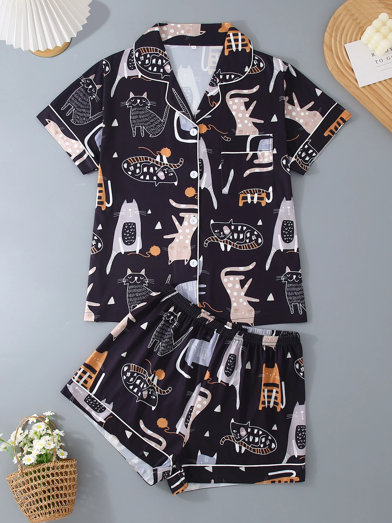 

Пижамный комплект из 2 предметов с рисунком котенка из мультфильма, с открытым верхом с зубчатым воротником, короткими рукавами и свободными эластичными шортами.