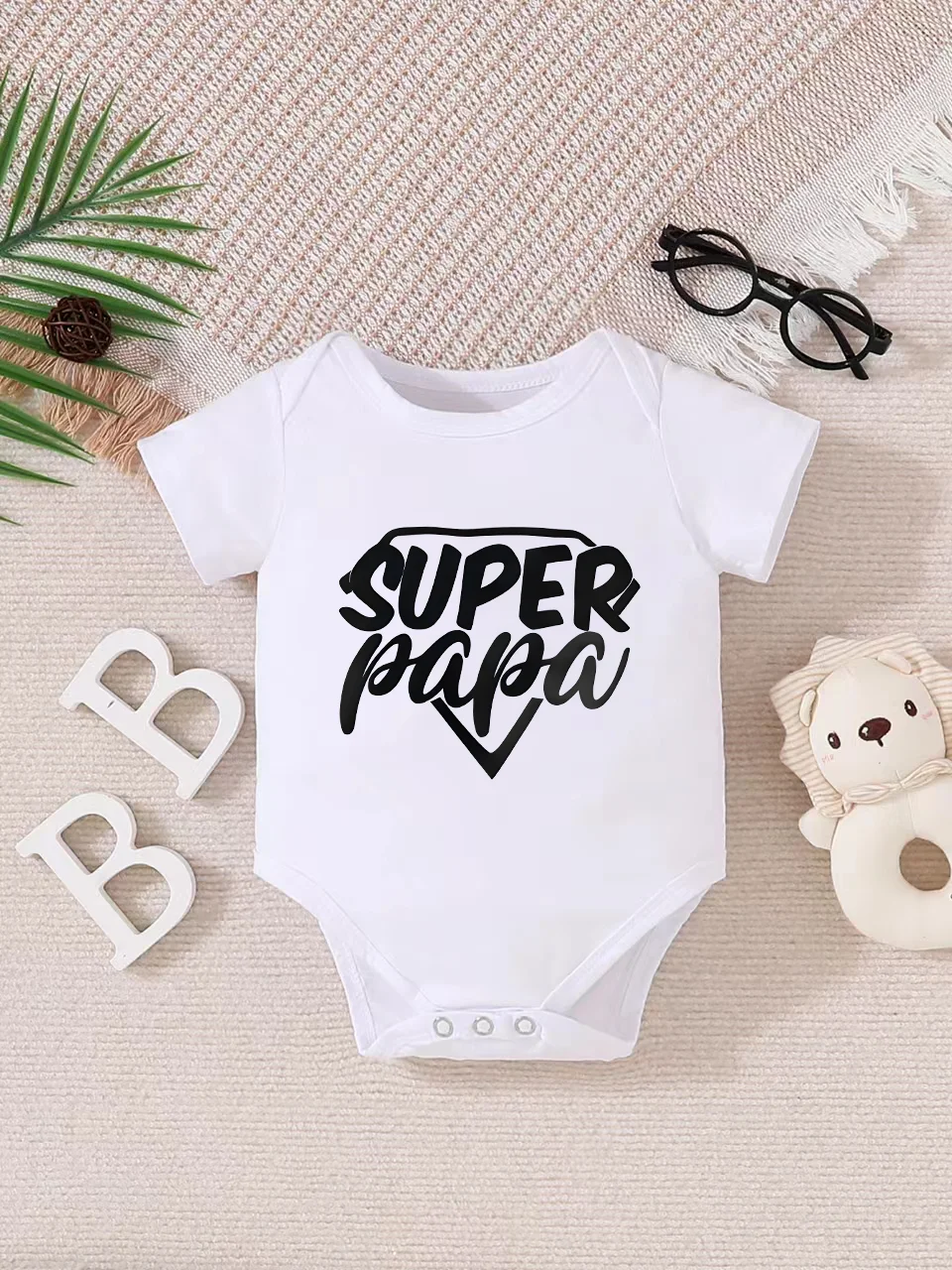 Playful letter-printed baby short-sleeve triangle bodysuit. Button closure for easy dressing, machine washable