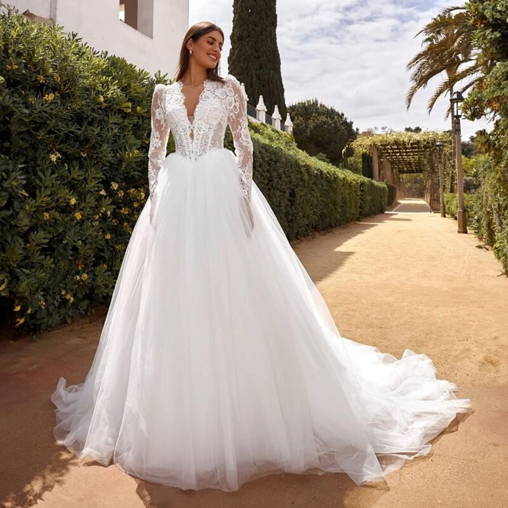 فستان زفاف بوهو من الدانتيل بأكمام طويلة ورقبة على شكل حرف V مع ذيل سويب مطوي مزين بحفلات الزفاف على الشاطئ مصنوع حسب الطلب