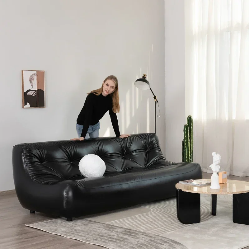 Black leather floor-to-ceiling caterpillar-shaped sofa