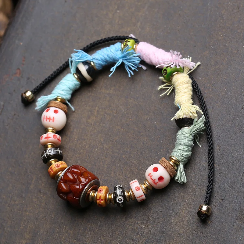A Tibetan-style handmade bracelet featuring yak spacers, A-dai thread beads, and carved bone accessories.