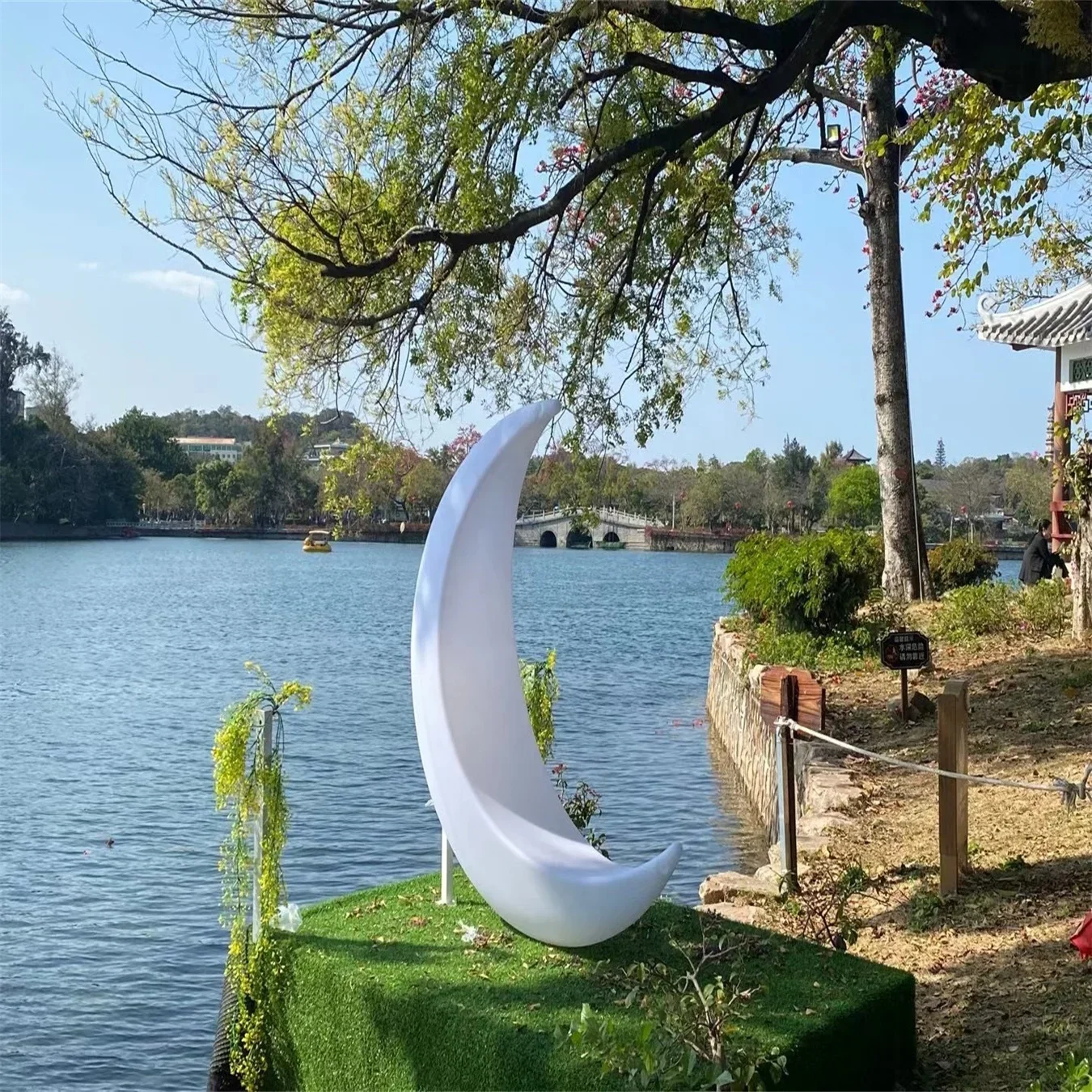 Stylish luminous Crescent moon-shaped hanging chair used as a swing in the scenic leisure area