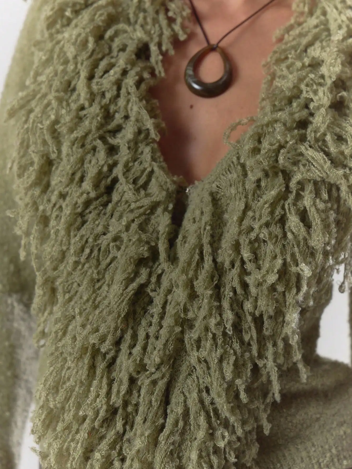 Kardigan w kolorze oliwkowej zieleni z puszystym wykończeniem i rękawami z frędzlami, idealny na jesień i zimę, zapewniający elegancję na co dzień.