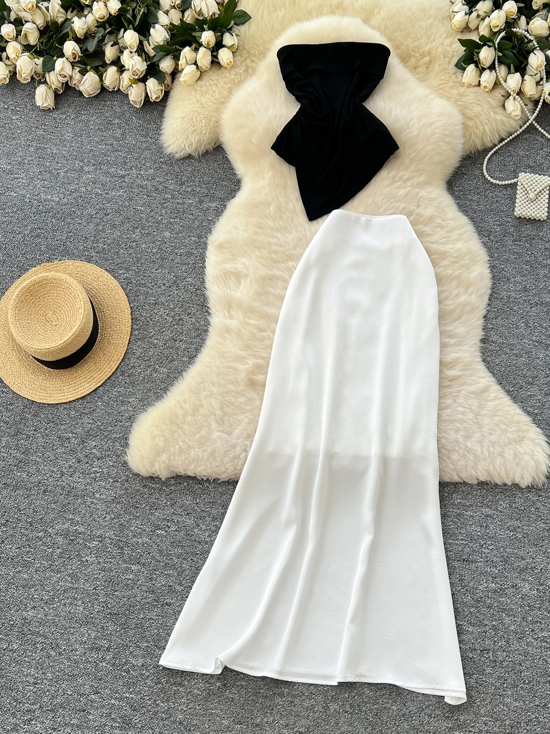 

Комплект: топ-жилет с открытыми плечами и асимметричная атласная юбка с завышенной талией. Женский модный костюм с эффектом утончения талии.