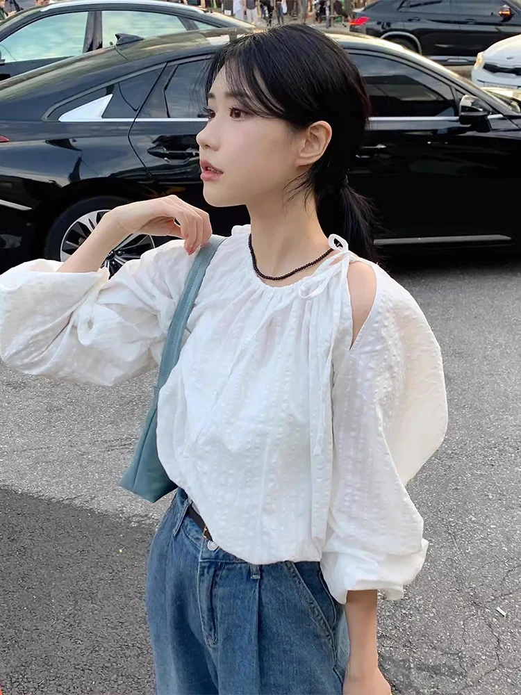 シックなラウンドネック長袖中空デザインの女性のシャツ巾着ルーズフィット多用途秋のファッションカジュアル通勤スタイル