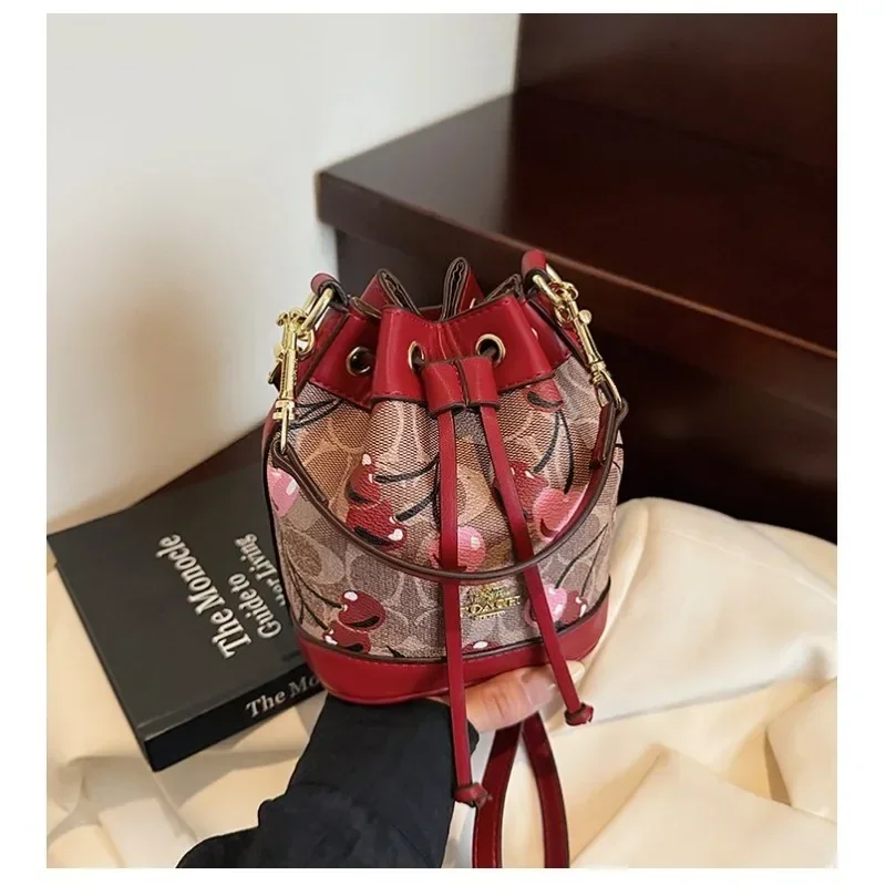 

​ ​ "2025newTextured Bucket Bag Женская сумка Artisan на плечо с завязками Винтажный мотив Crossbody Heritage Accent Carrier" ​ ​