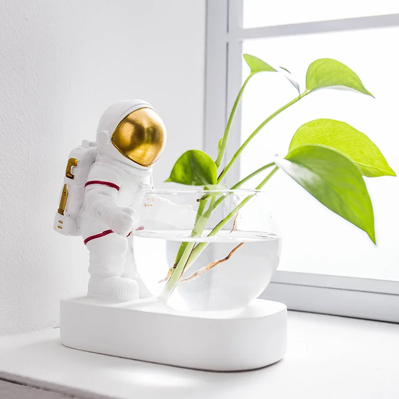 Astronauten und Astronauten kultivieren grüne Pflanzen hydro ponisch mit Glas wasser blumenvase Wohnzimmer dekoration