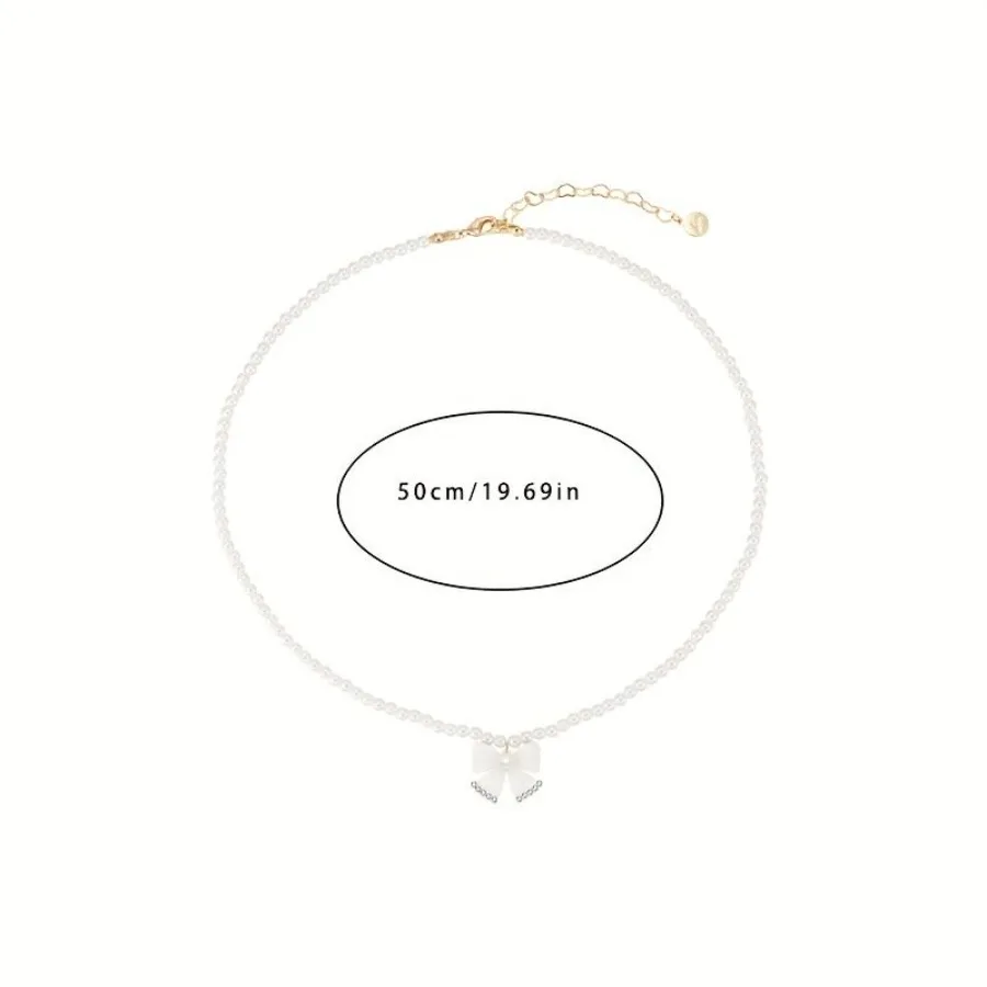 Naszyjnik damski w stylu kokieteryjnym z sztucznymi perłami, łańcuszkiem i zawieszką z kokardką, niszowy design, łańcuszek na obojczyk.