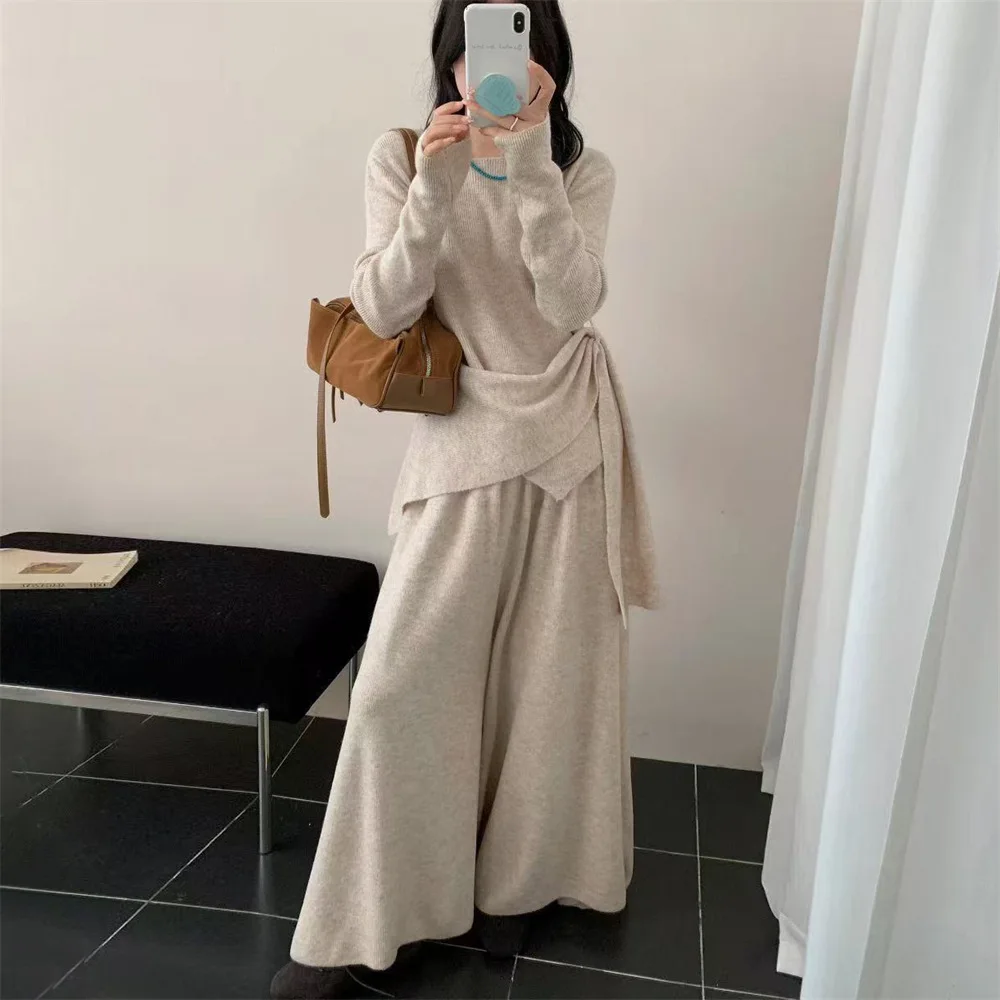 

Весенне-осенний комплект из трикотажного свитера с асимметричным кроем и брюк с высокой талией и широкими штанинами для женщин, состоящий из пуловера с длинными рукавами и брюк.