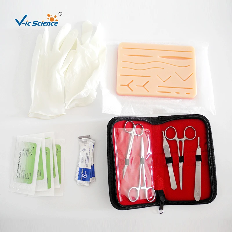 Flat suture pad with wounds and mesh, tool kit, blades and sutures with threads