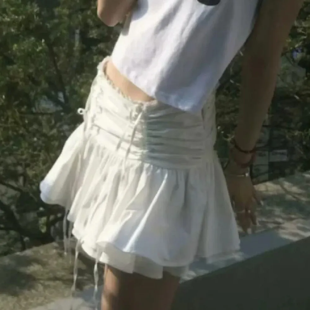 Mini gonna a ombrello con volant a vita bassa in pizzo impiombato da ragazza da balletto con fiocco sul davanti pieghe con volant sull'orlo Skater gonne coreane bianche