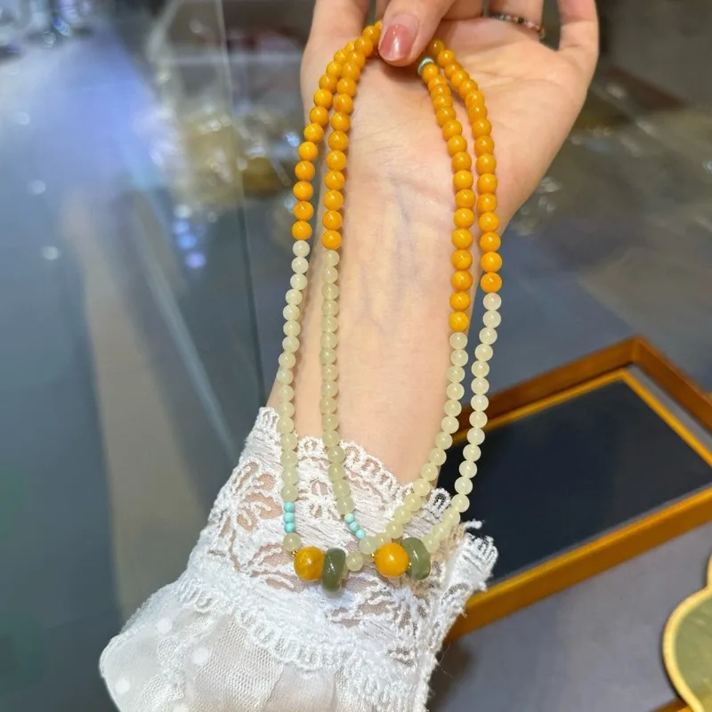 Natural Russian amber a chicken-yellow hue paired with Hetian jade in a double-strand bracelet size 5 to 6 millimeters