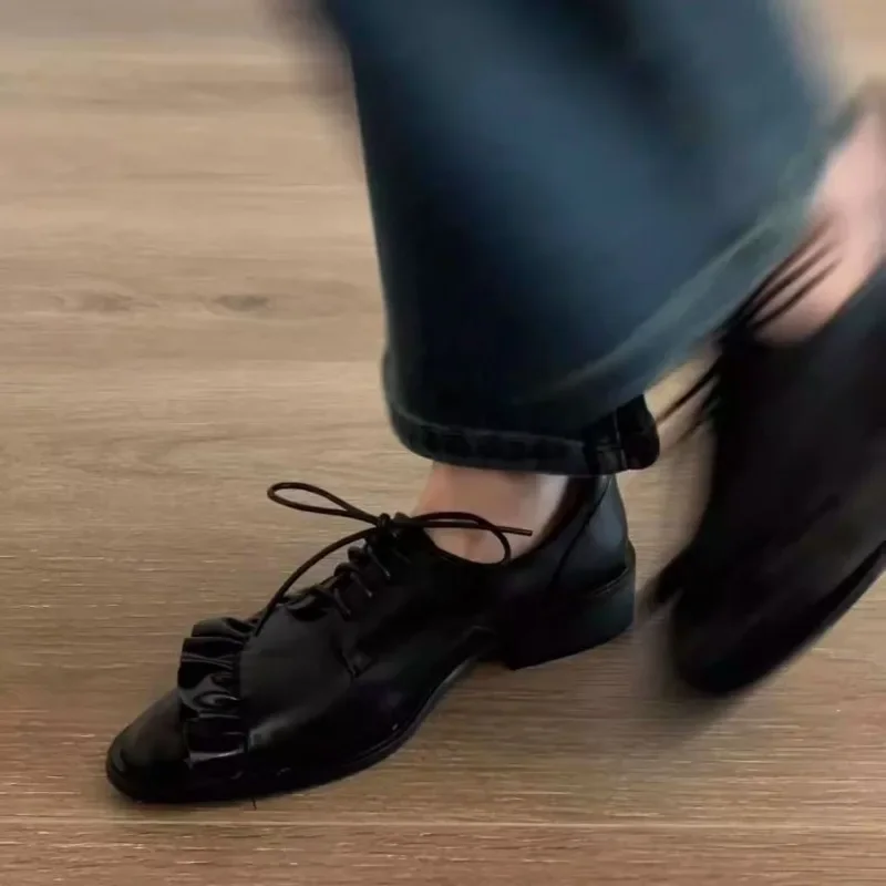 2025 Nuevos zapatos planos con cordones y cabeza redonda con volantes negros para mujer, zapatos informales neutros de cuero PU para fiesta y uso diario