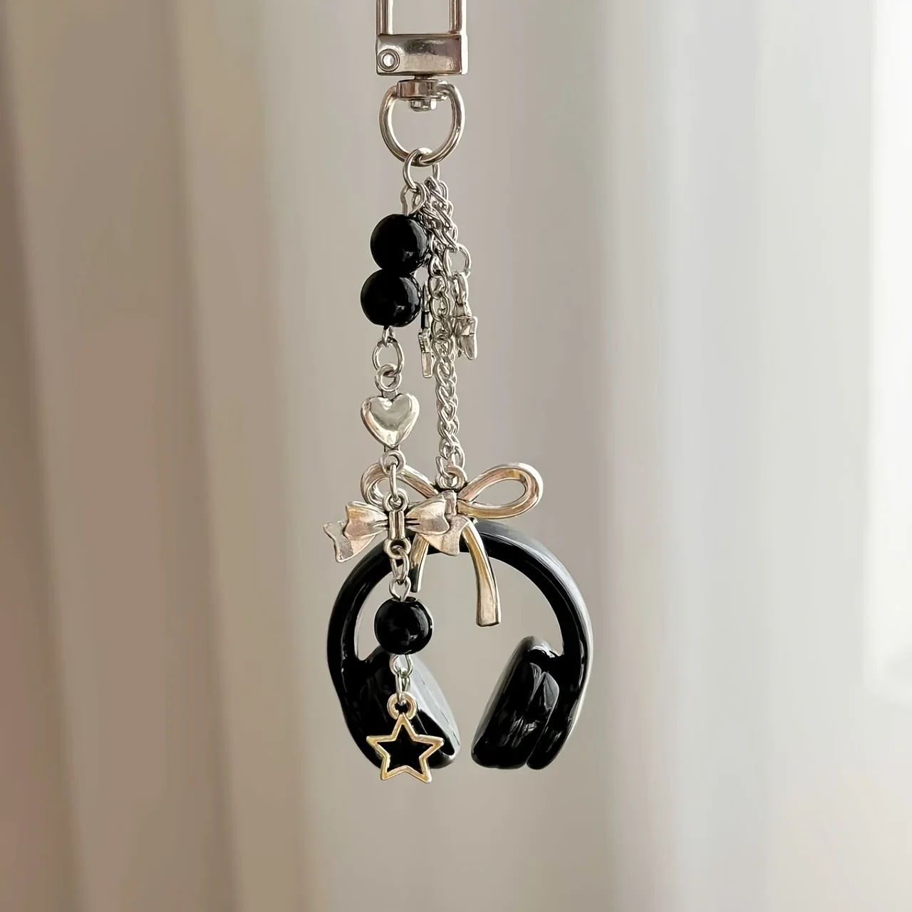 

a high-value Y2K earphone bracelet, black and silver color scheme star bow beaded pendant, the same accessories as sweet girls and spice girls, personalized bag mobile phone lanyard, trendy music theme trinkets couple models