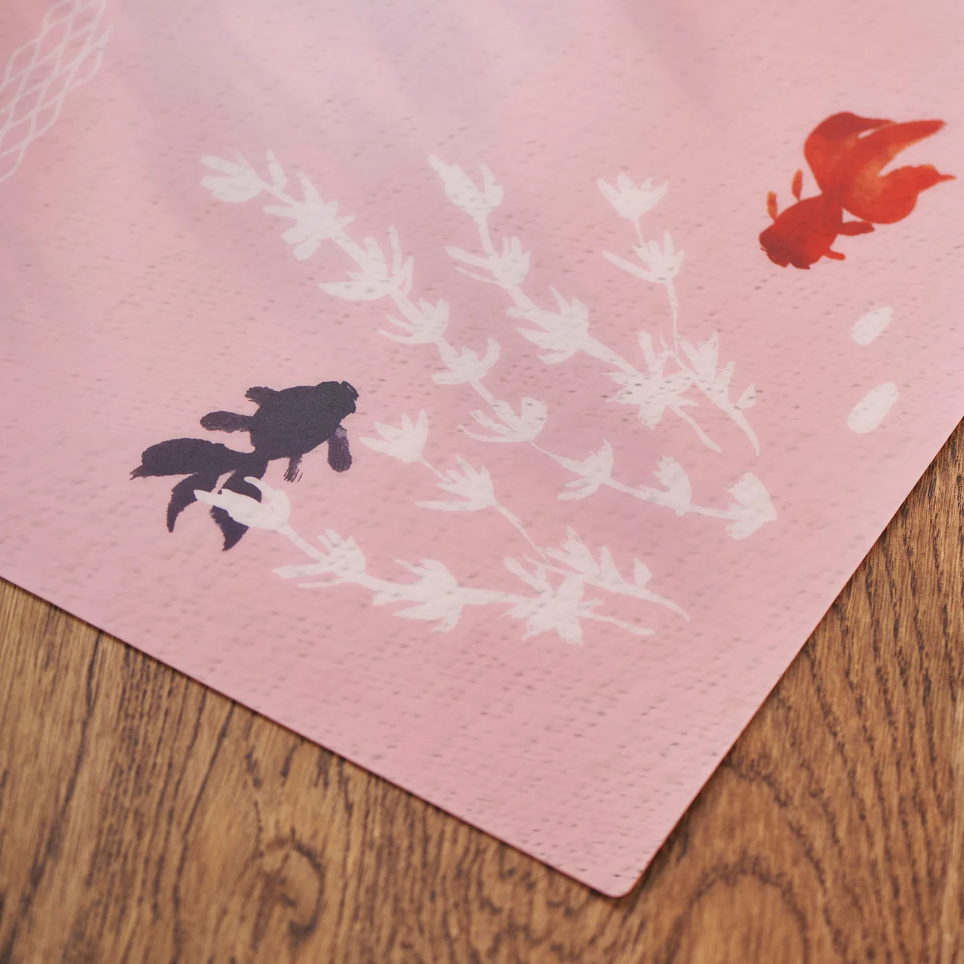 The placemat is adorned with lively goldfish and aquatic plants, symbolizing the wish for good luck, prosperity and abundance. I