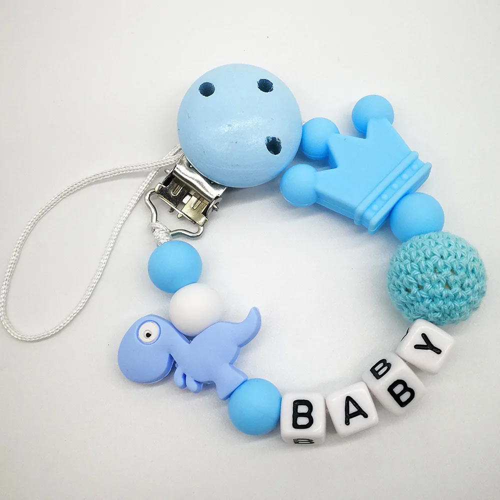 Drewniany łańcuszek do smoczka z motywem dinozaurów na prezent na baby shower