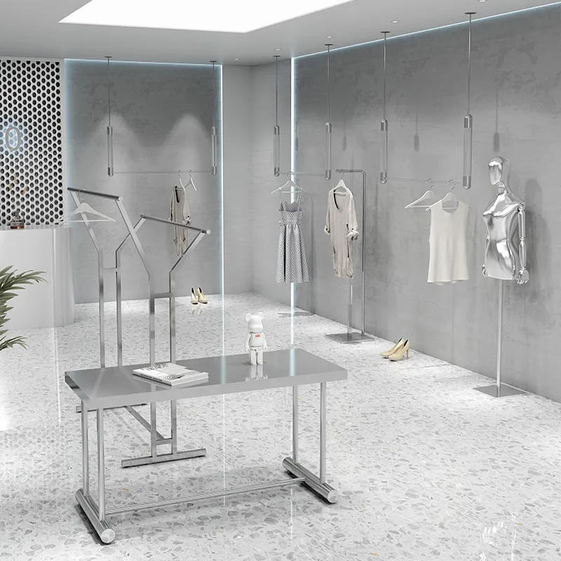 Clothing store display racks: Stainless steel silver hanging clothes racks hang on the wall, displaying shelves for women's