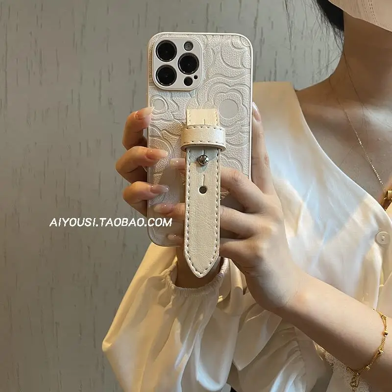 Premium camellia wristband is suitable for Apple 13 mobile phone case iPhone16Promax high-end 11 leather pattern anti-drop.