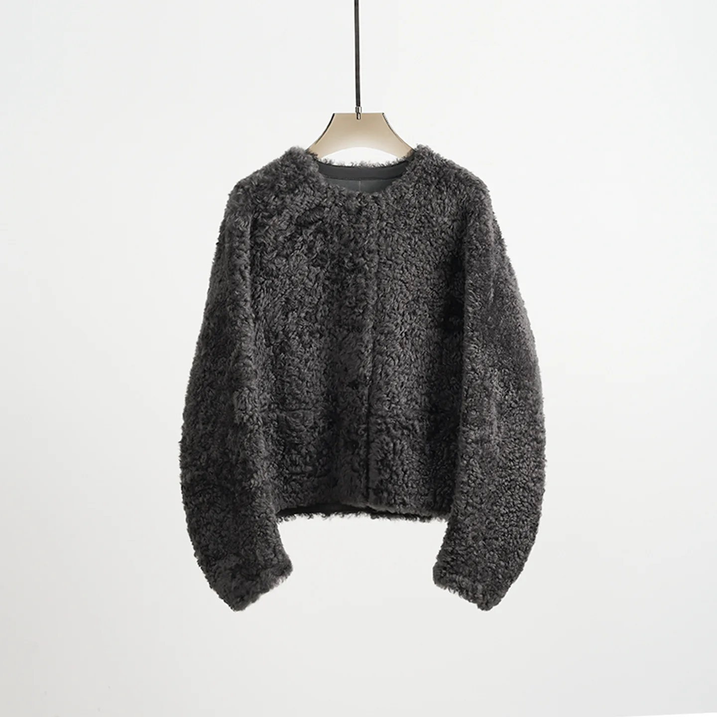 Abrigo de piel reversible recortado y holgado con cuello redondo de punto de lana y piel de oveja de primera calidad ultra minimalista