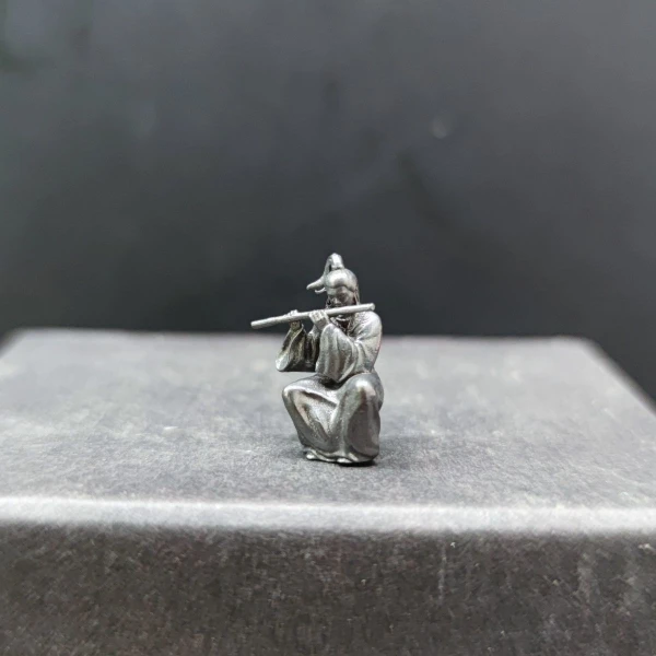 A Miniature Figure of Han Xiangzi, An Ancient Martial Artist Sitting in A Position Playing The Flute, and A Rockery Figurine