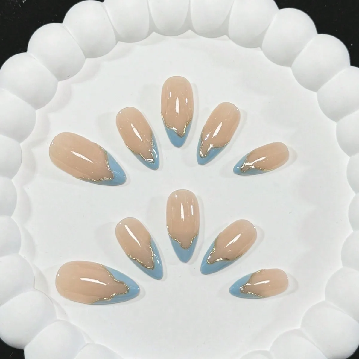 Dieci pezzi di unghie francesi irregolari nude e blu a forma di mandorla fatte a mano con contorno linea oro, fresche e semplici