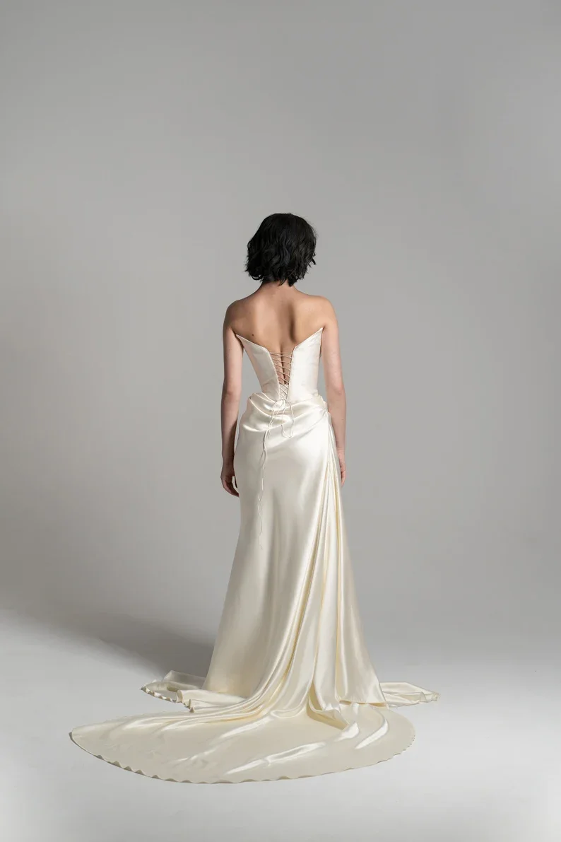 Suknia ślubna katedralna z satyny w kolorze białej kremowej, drapowana, z gorsetem w talii, z trenem do ziemi, model 2025, szyta na miarę.