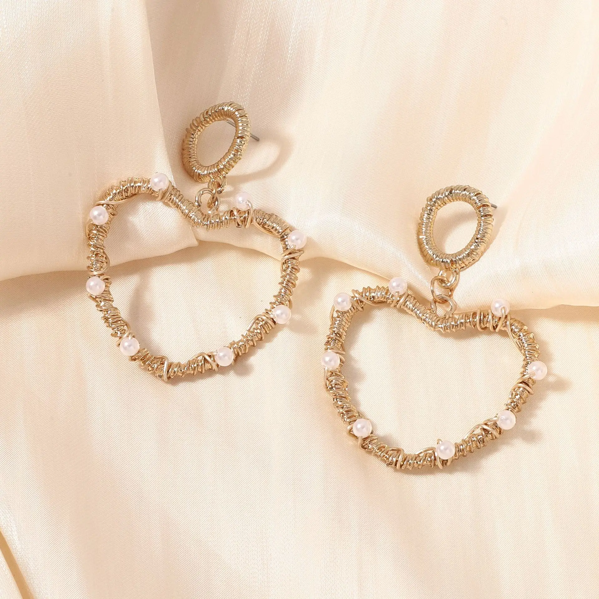 Classic popular heart-shaped pure hand-wound hollow imitation pearl love earrings, fashionable and versatile