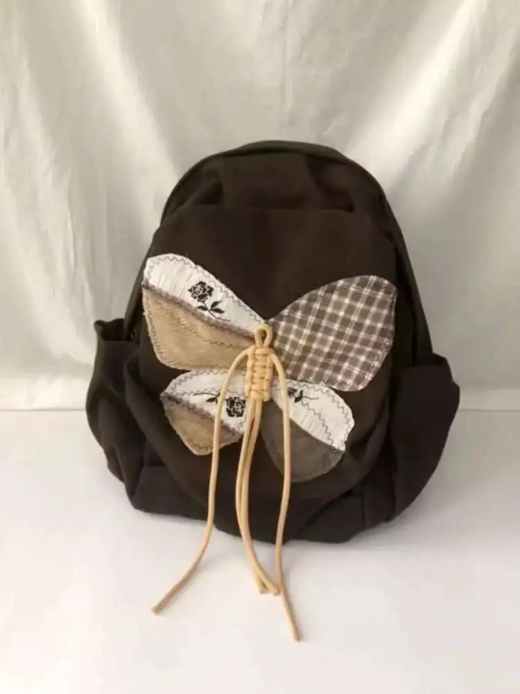 2025 ใหม่ Patchwork ผีเสื้อกระเป๋านักเรียนกระเป๋าเป้สะพายหลังไหล่กระเป๋านักเรียนวัยรุ่นของขวัญ B1979 hit