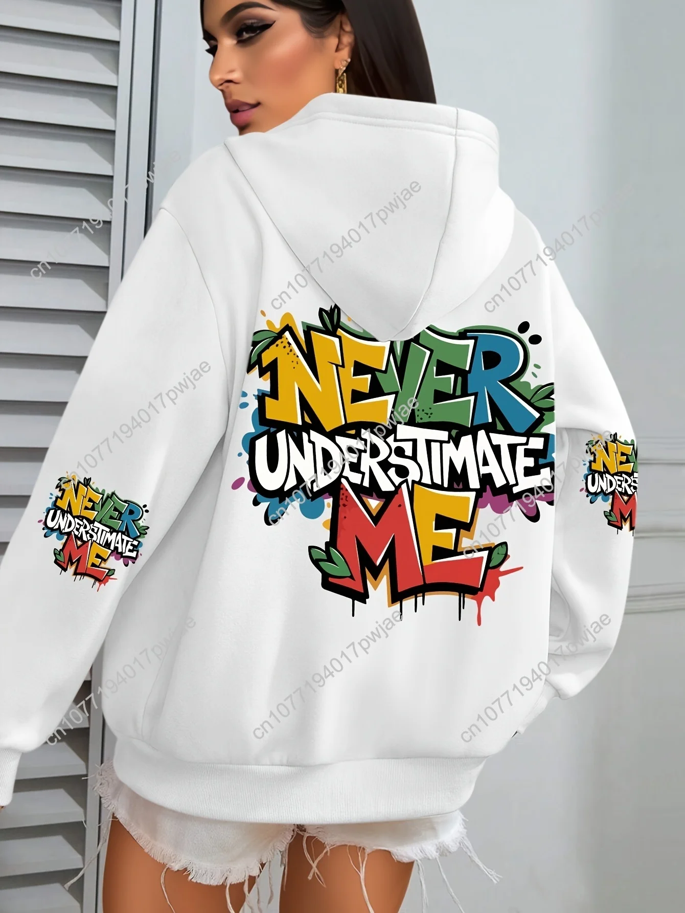 Moletom feminino plus size com estampa grafite hip hop – gráfico "NEVER UNDERESTIMATE ME", verde vibrante com design de respingos coloridos,