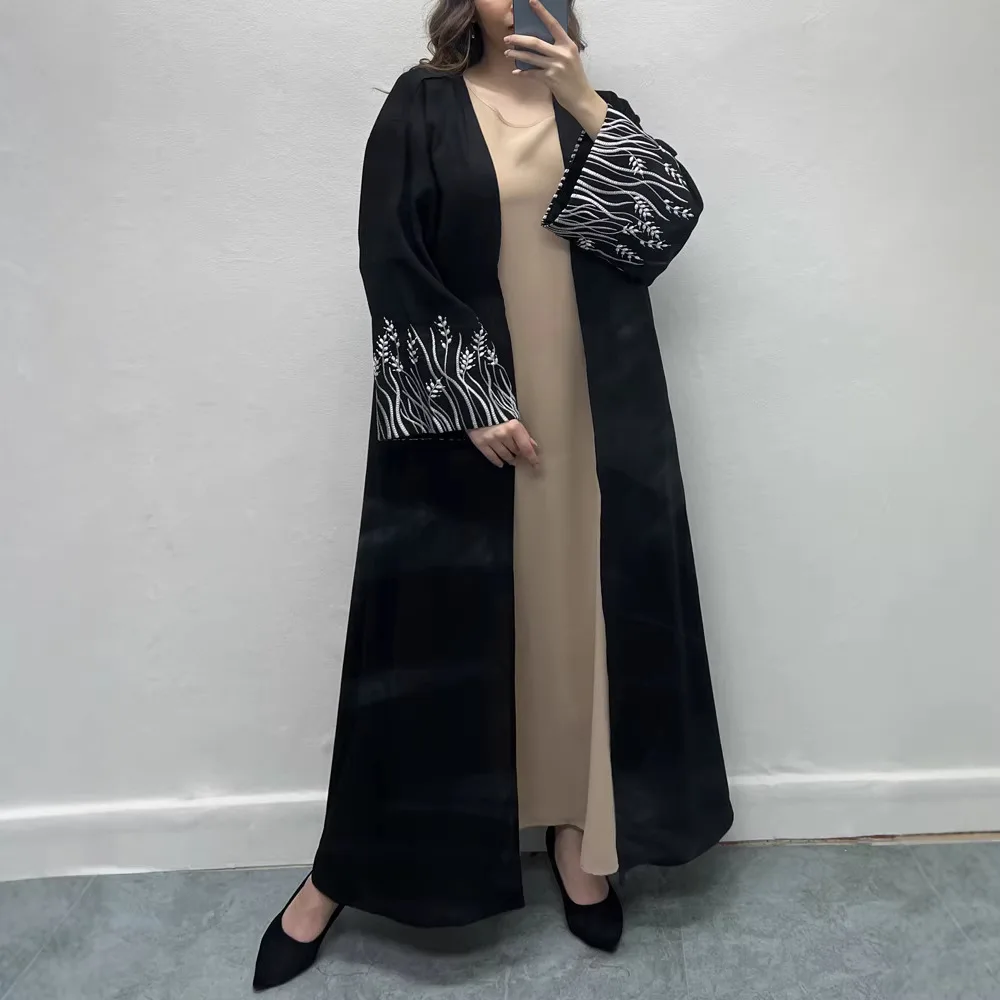 

Праздничное платье-абайя черного цвета в дубайском стиле для мусульманок: элегантный и скромный дизайн с золотой вышивкой на рукавах