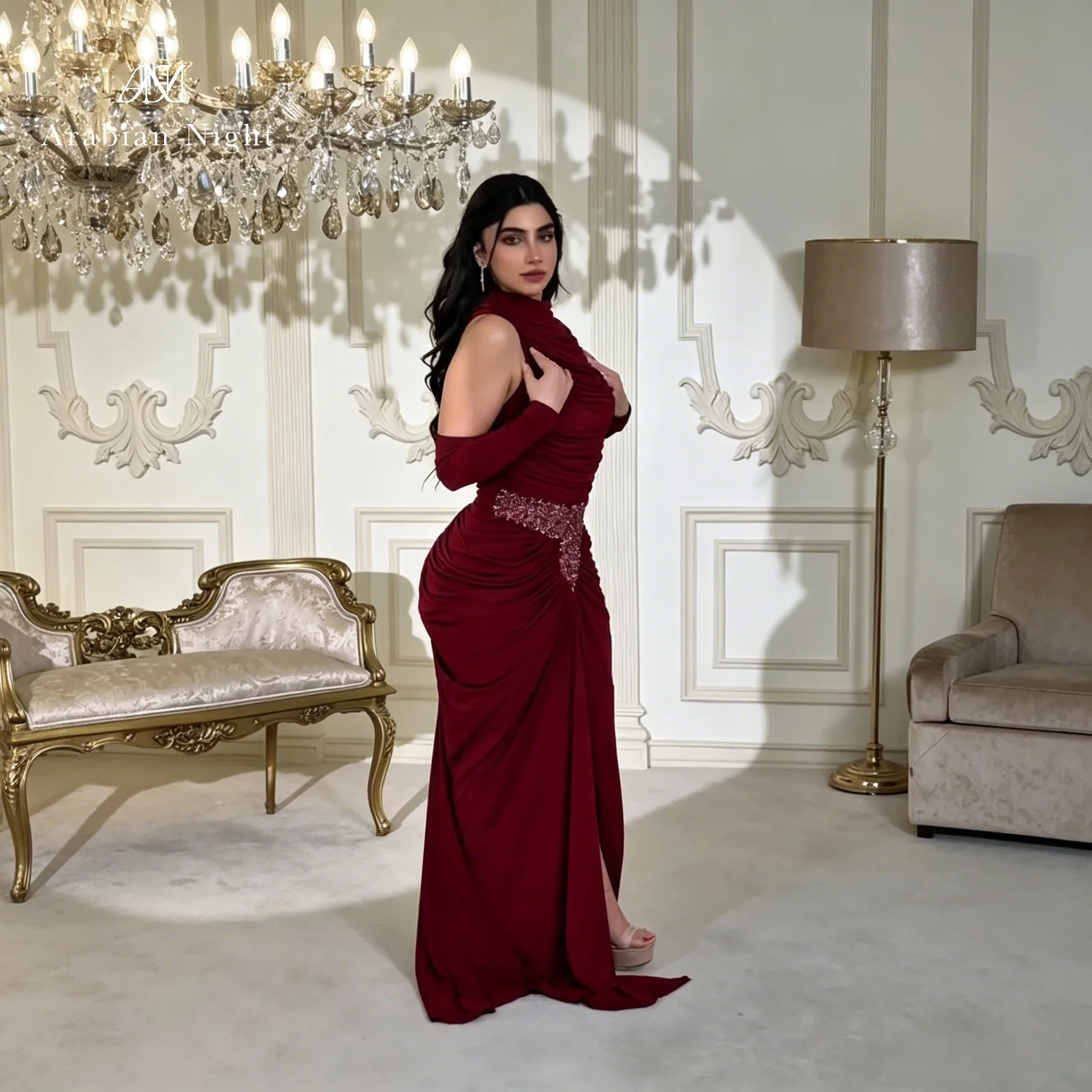 Burgundy floor-length formal mermaid gown featuring a high neck sleeveless cut pleated waist and beaded detailing