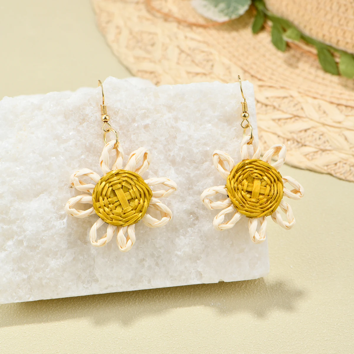 Pendientes de girasol tejidos a mano, estambios dorados con pétalos blancos, que muestran artes frescas