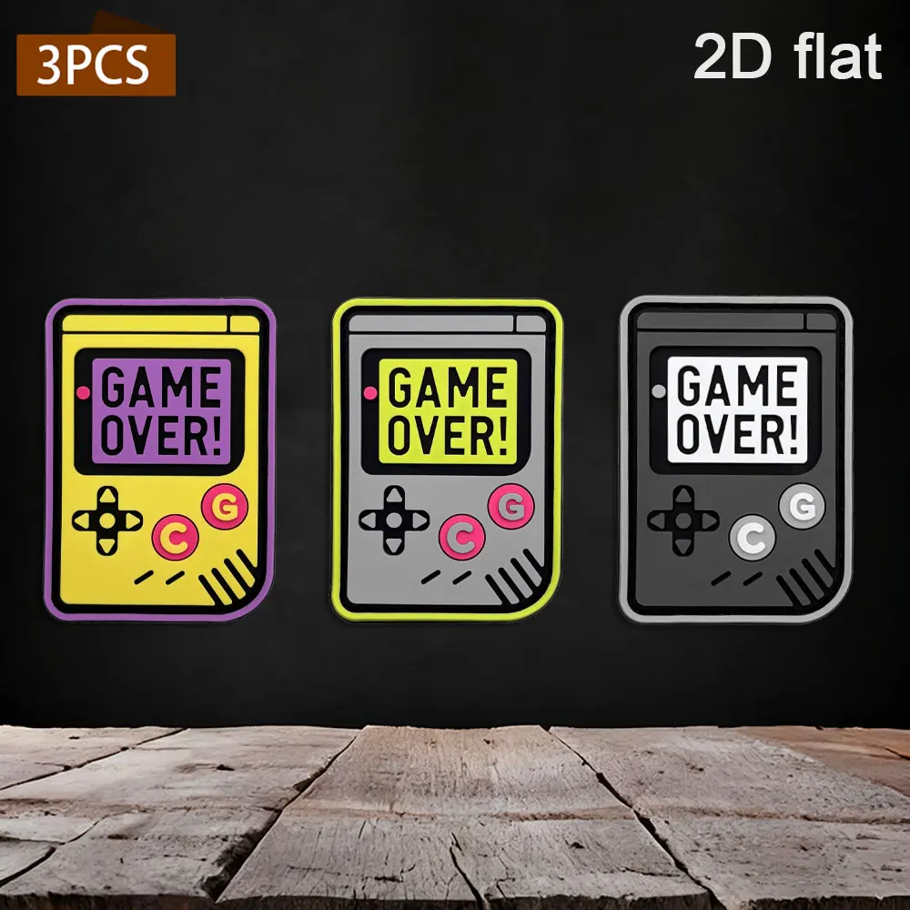 Available in 1pc/2pcs/3pcs options. 2D retro handheld game console PVC rubber. Comes with GAME OVER embossed patches in yellow, gray, and black colors. Waterproof, wear-resistant, and not easy to fade. Suitable for gaming enthusiasts as a trendy decorative patch for gaming jackets, work bags, and functional vests