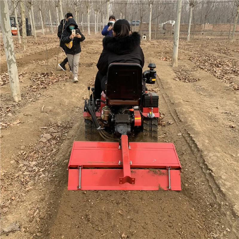 Household small agricultural rotary tiller rides on tracks with engine core for hard and clay trenching