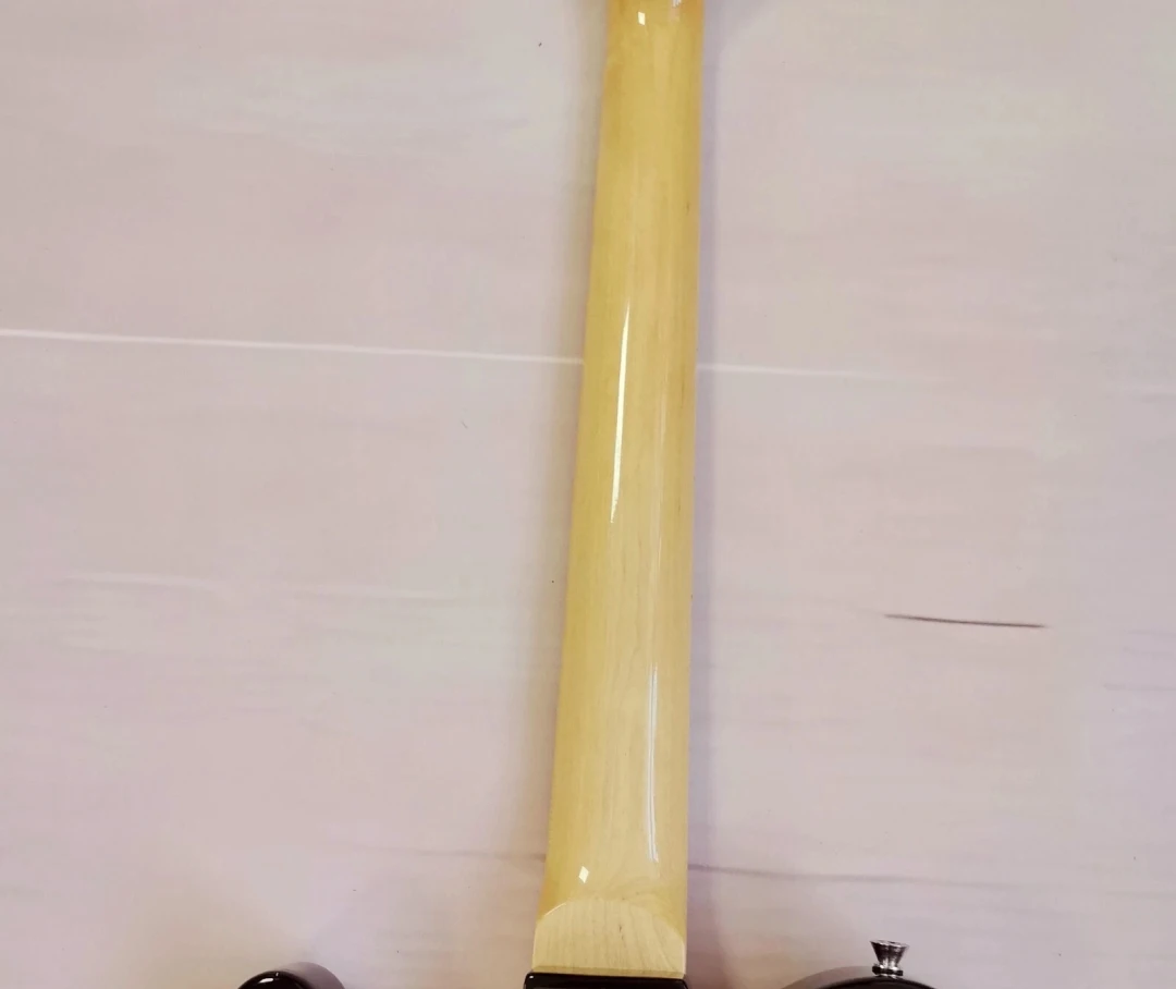 جيتار كهربائي أسود برقبة من خشب القيقب يتميز بلوحة واقية كبيرة وجسم ماهوجني قوي وجودة استثنائية