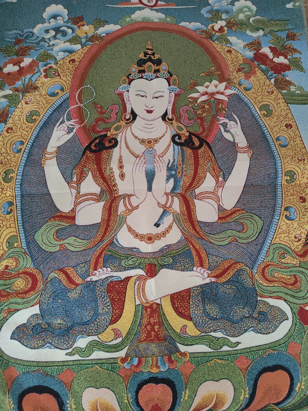 Nave hangs a picture of Xizang Thangka silk embroidered four-armed Guanyin Bodhisattva as a decorative painting of China.