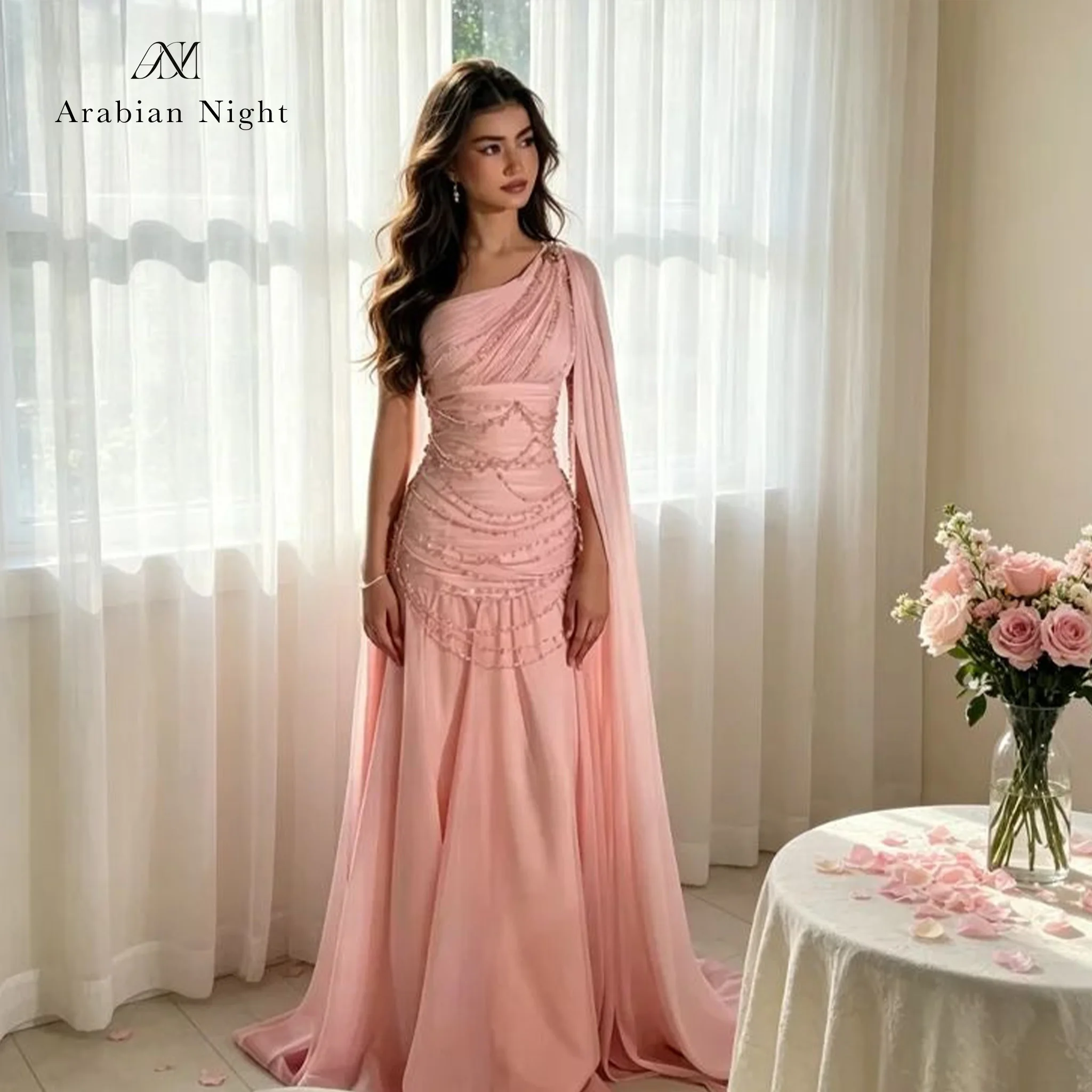 Pink floor-length formal gown featuring a pleated beaded one-shoulder bodice with a draped shoulder detail