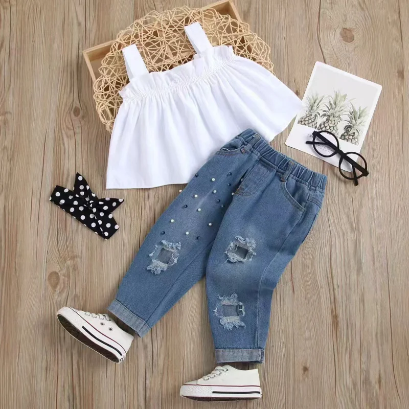 Children's summer denim outfit for girls: white lace camisole top with beaded embellishments, ripped denim long pants, and match