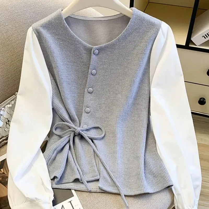 

Женская трикотажная блузка темно-синего цвета с белыми контрастными рукавами и завязками на талии