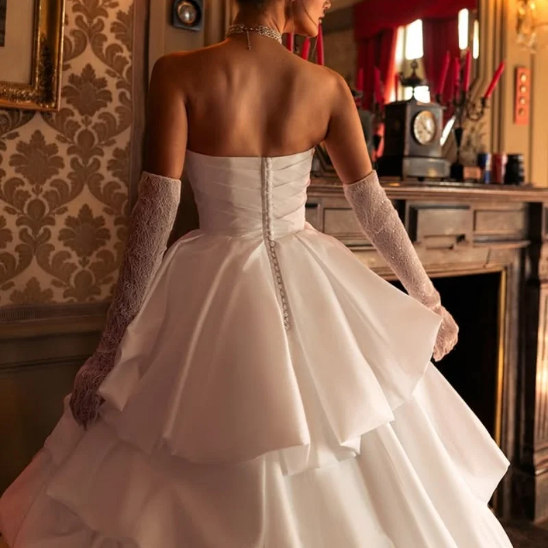 Abiti da sposa con applicazioni in raso bianco di abiti da sposa con decalcomania a strati senza maniche con spalle scoperte realizzati su misura