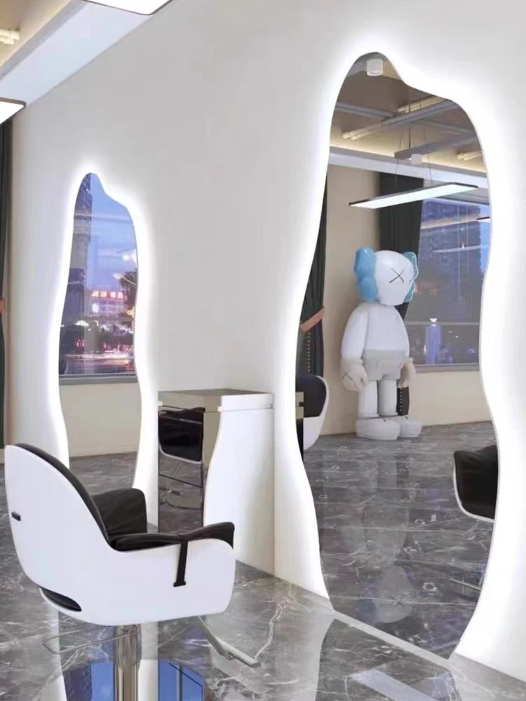 Single sided minimalist haircut with irregular mirror hanging on the wall and dedicated light for hair salons