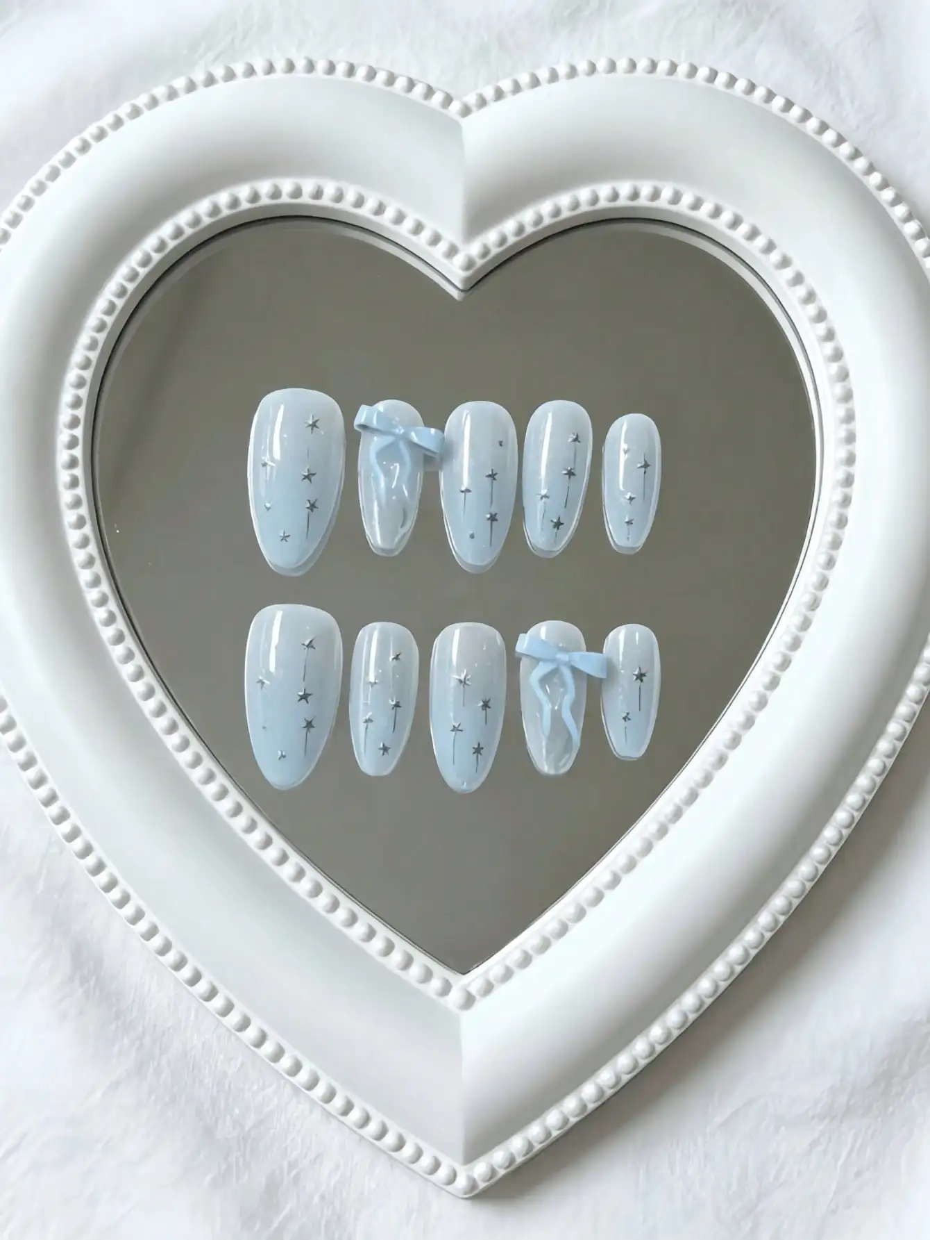 10 Pieces of Medium-Length Almond-Shaped Press-On Nails, with a Clear Ice Blue Base Color, Featuring Hand-Painted Silver Lines, Stars, and Three-Dimensional Light Blue Bows, in a Fresh and Gentle Style, Perfect for Young Girls, Daily Commuting, and Summer Date Outfits, Comes with Jelly Glue and a Nail File